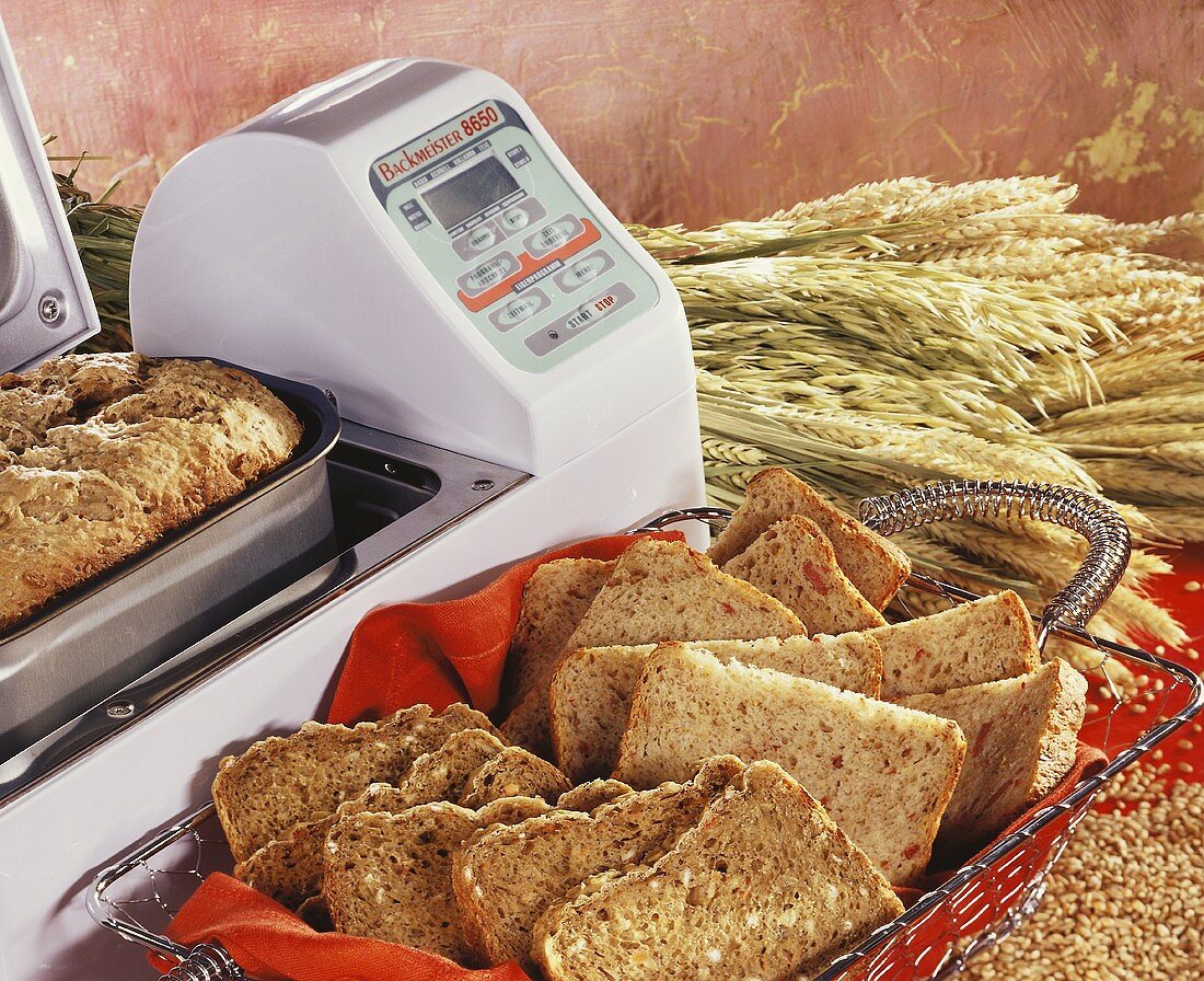 Brotbackautomat und verschiedene Brote im Brotkorb