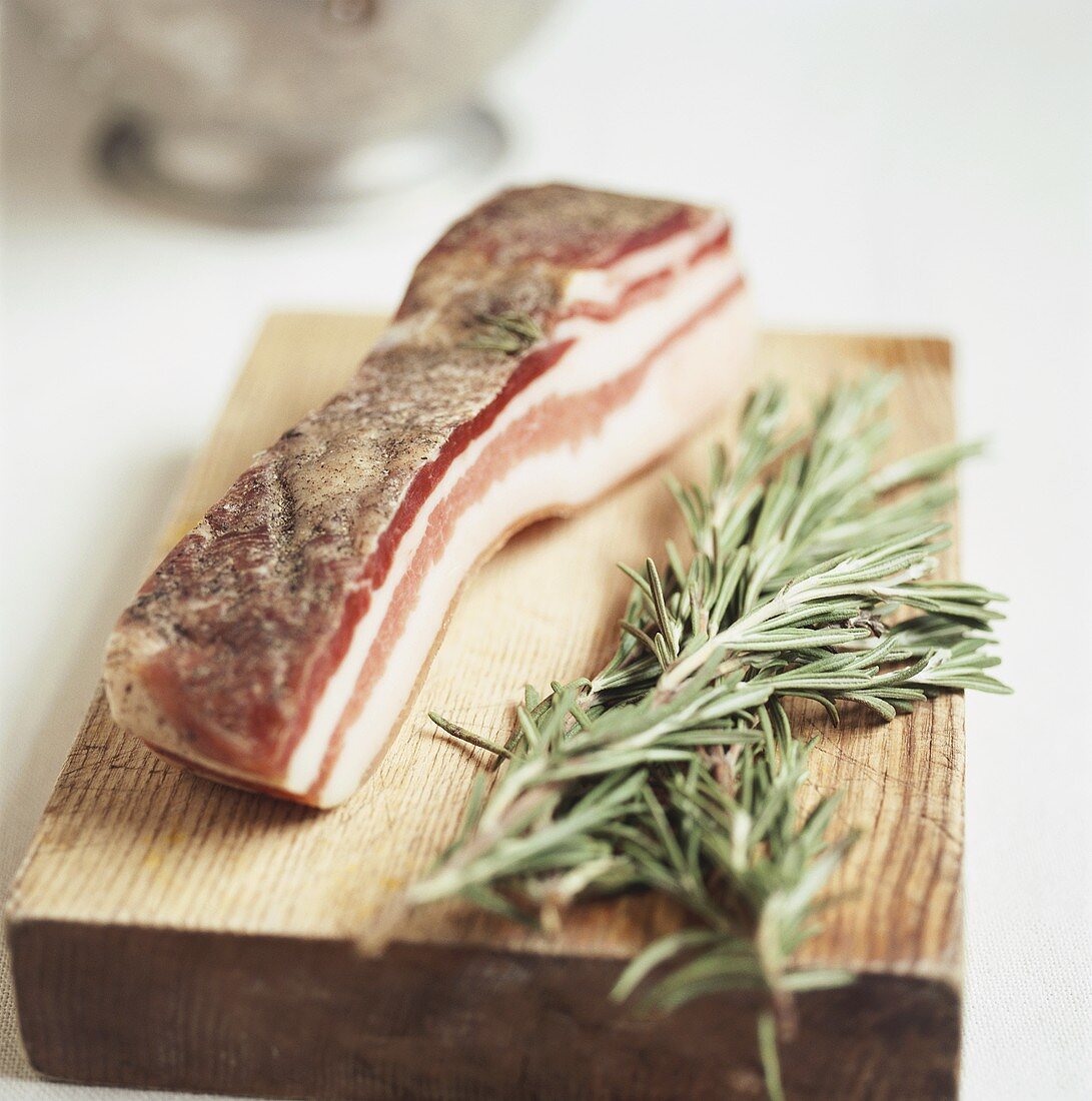 Pancetta and fresh rosemary on chopping board