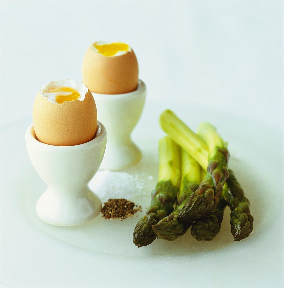 Two soft-boiled eggs and green asparagus