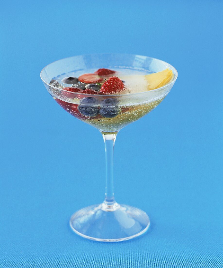 Champagne cocktail with mango and berries