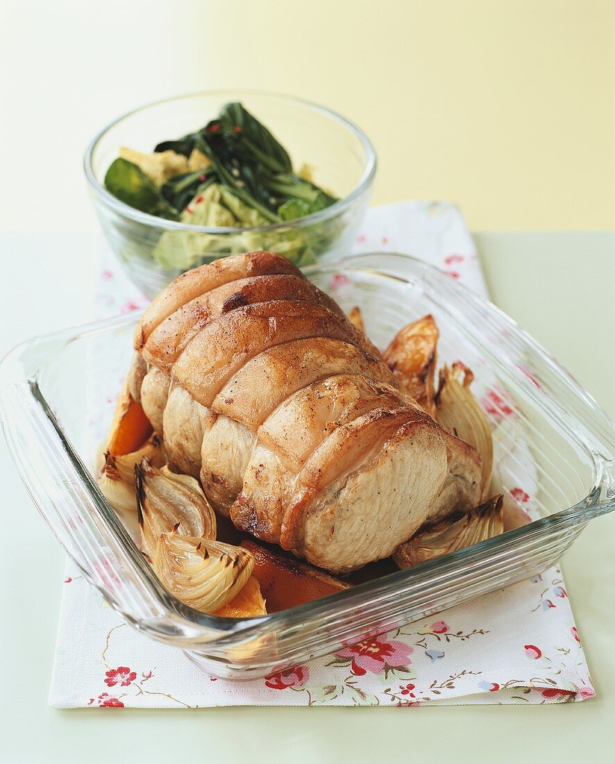 Roast pork roll with onions in glass dish