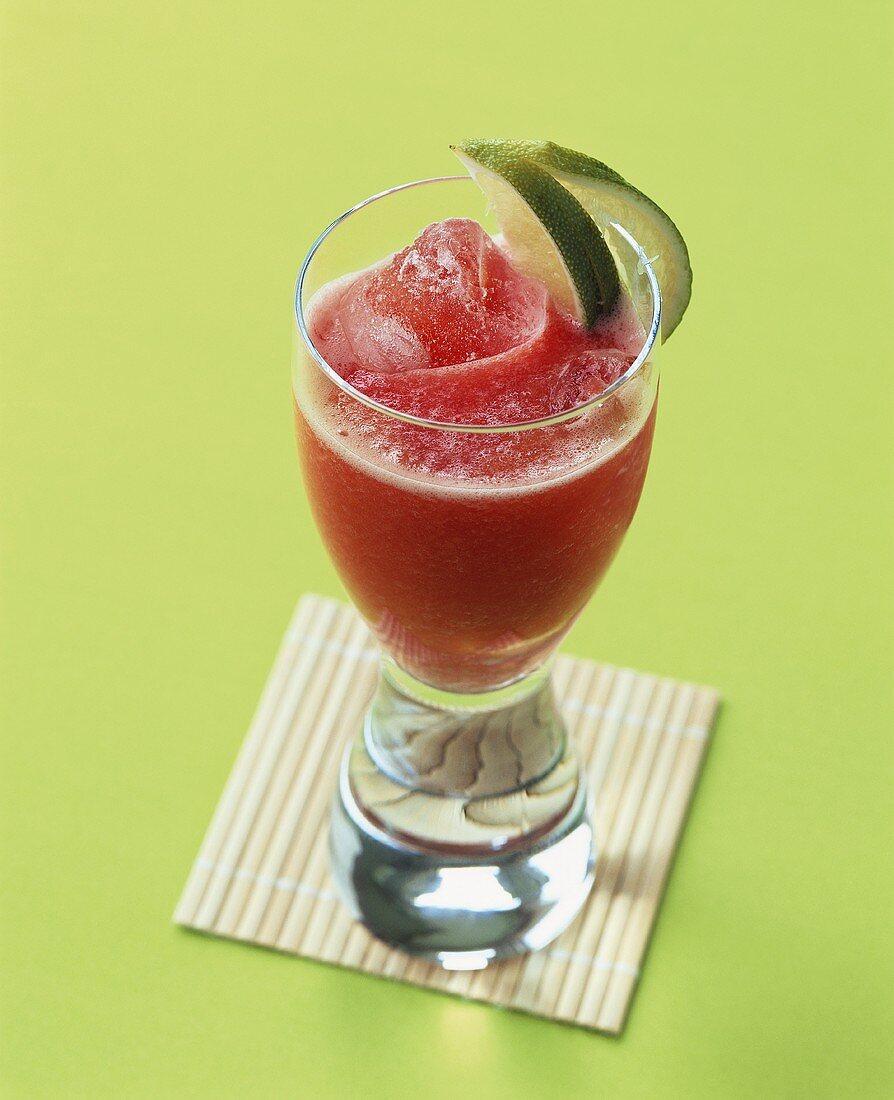 Tomato and watermelon drink with lime wedges