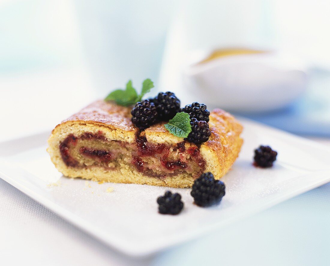 Piece of blackberry strudel with mint leaves