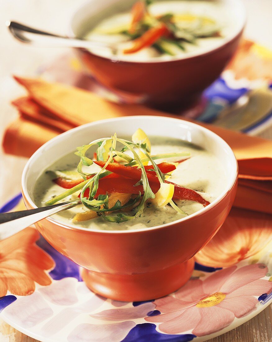Cold cucumber soup, garnished with peppers and rocket