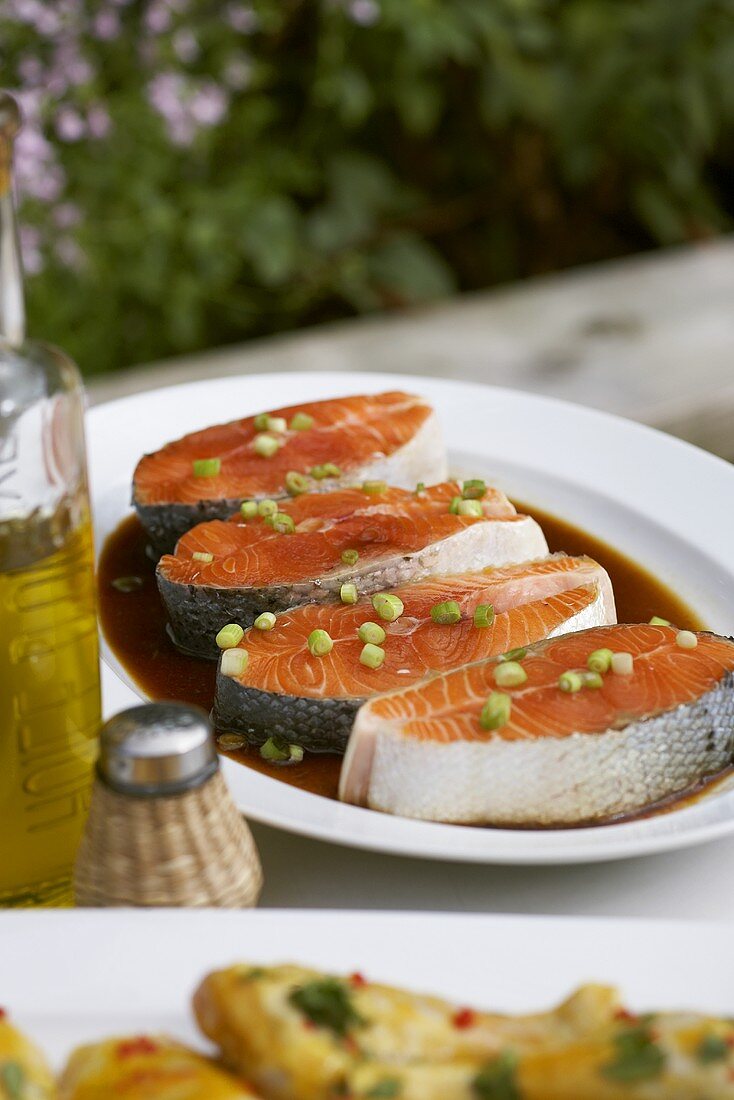 Marinated salmon cutlets for barbecuing on table in open air
