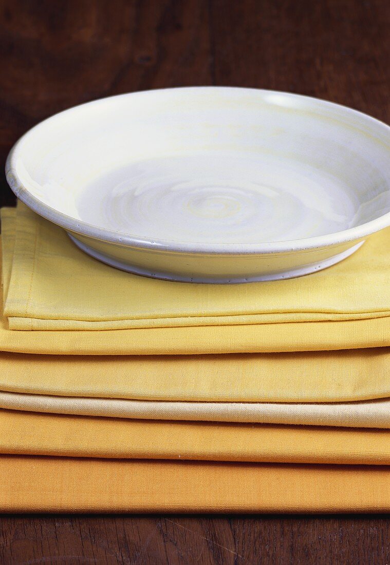 White plate with yellow stripes on yellow napkins