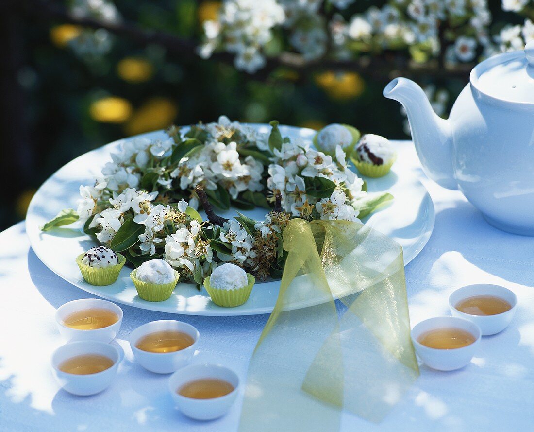 Pear truffles, tea and wreath of pear blossom on table