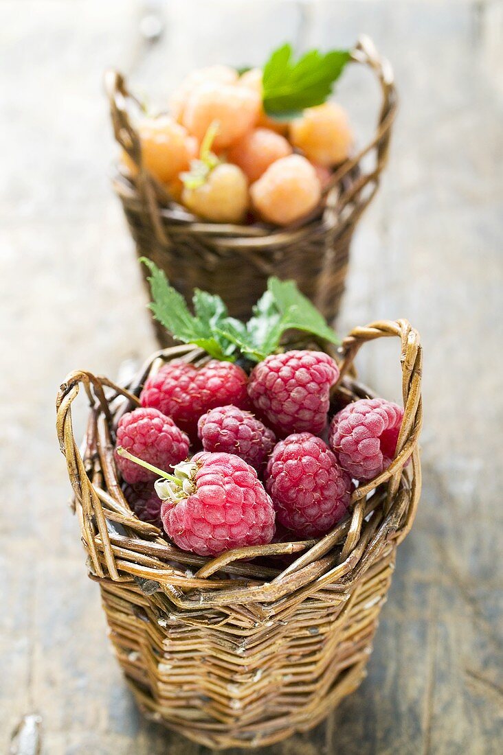 Red and yellow raspberries in two small baskets