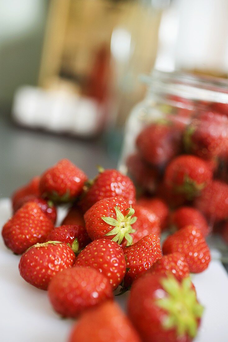 Fresh strawberries, some in jam jar