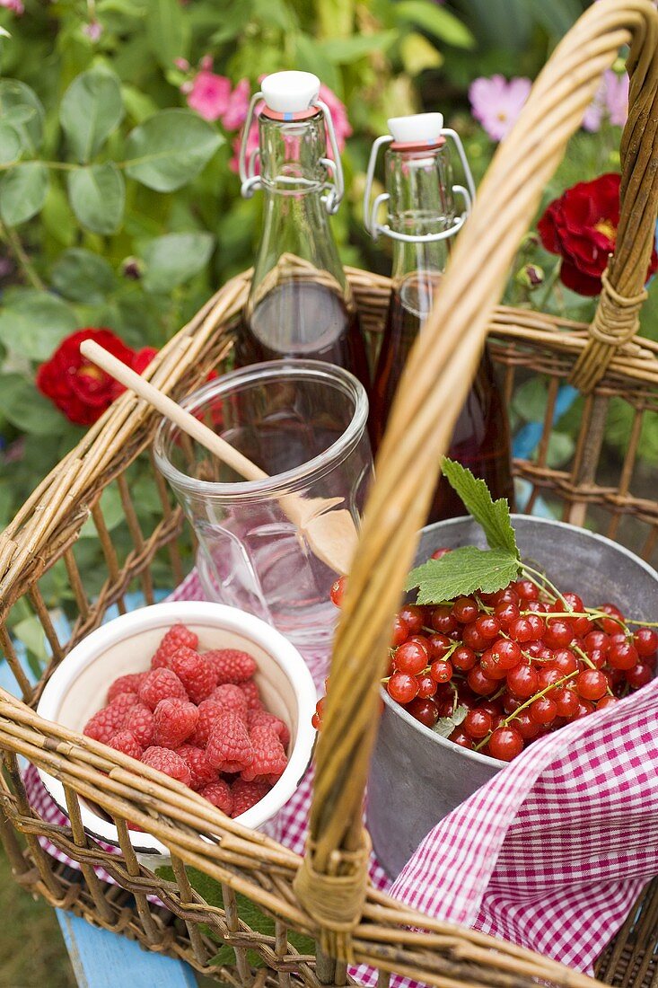 Fresh berries and bottles of juice in a basket