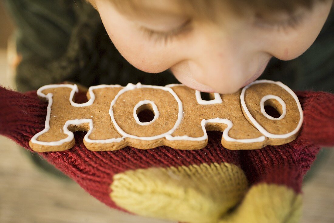 Kind beisst in Lebkuchenschrift HOHO