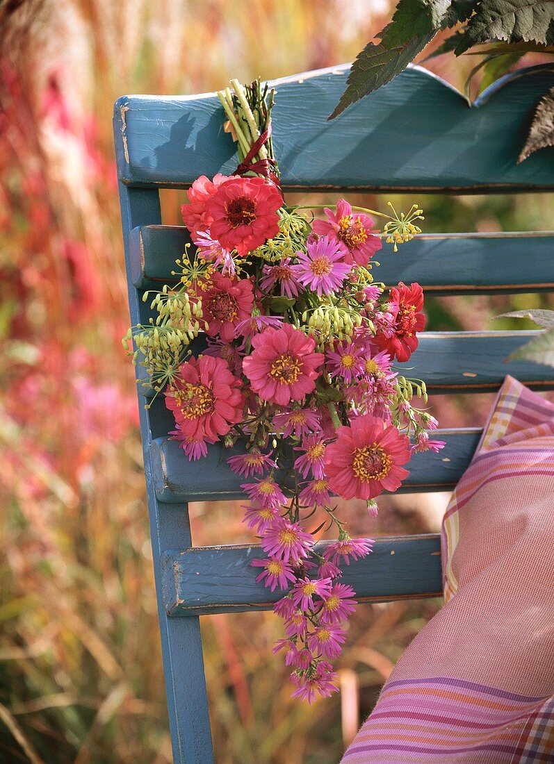 Kleiner Strauss mit Zinnien und Astern an Stuhllehne