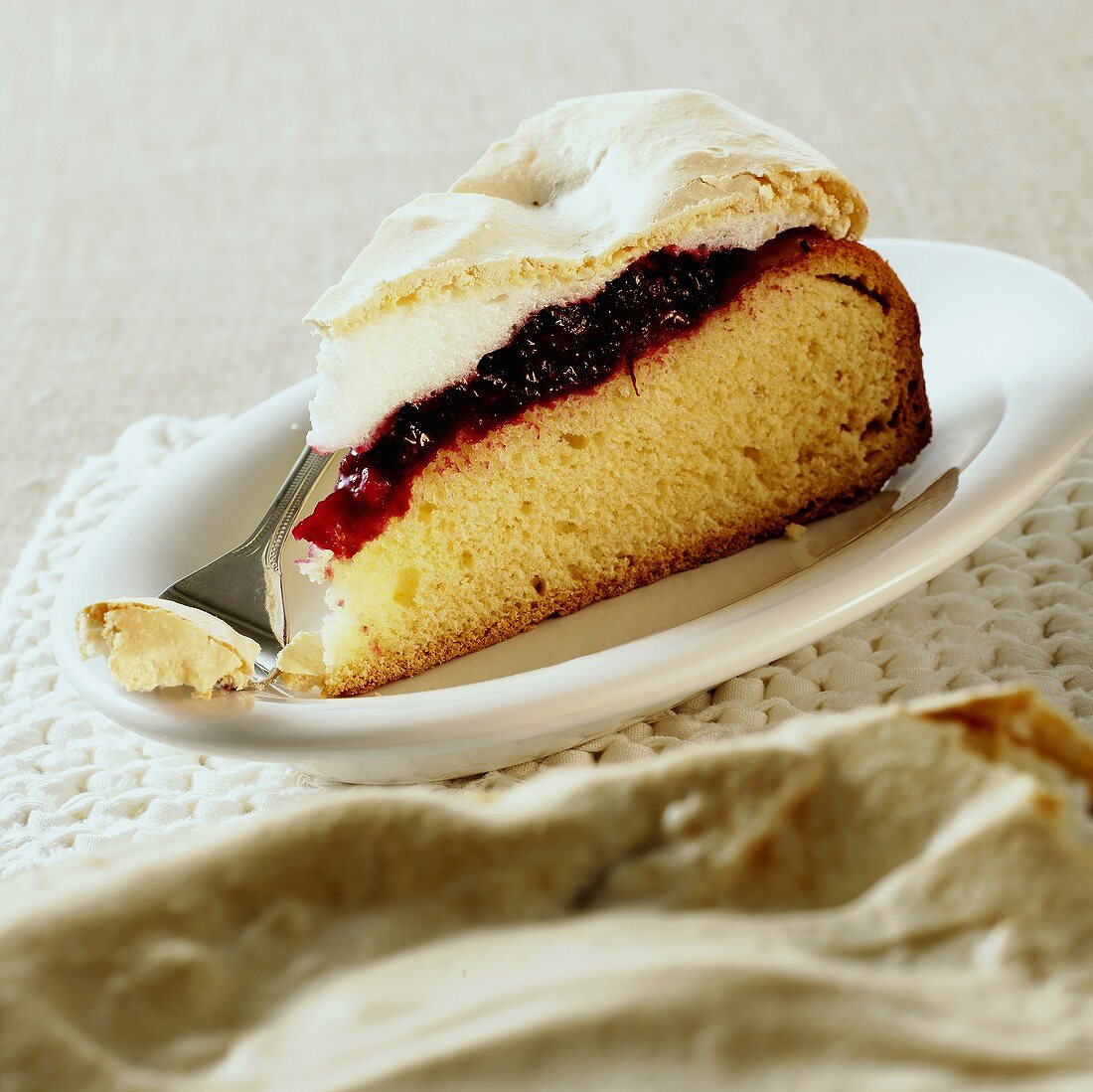 Stück Hefekuchen mit Brombeeren und Baiserhaube