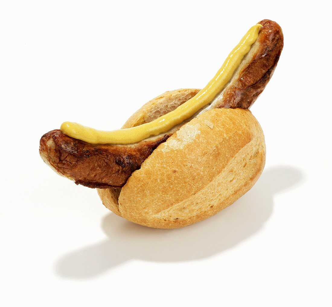 Sausage with mustard in bread roll