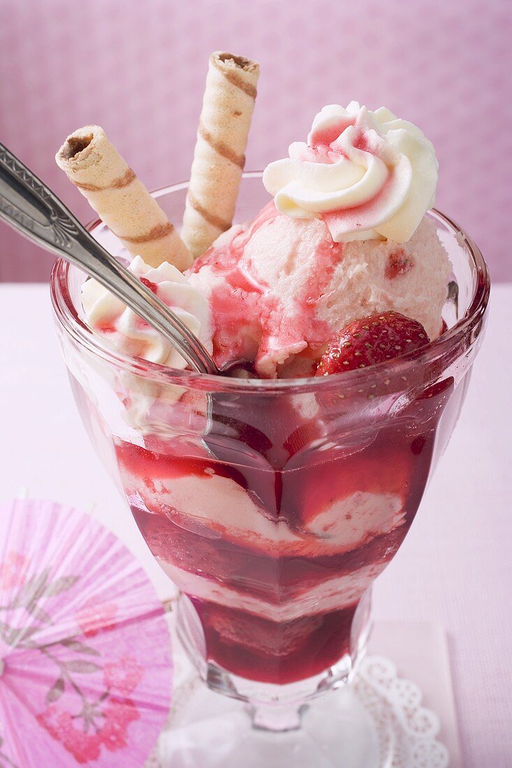 Strawberry ice cream with strawberries, cream & wafer rolls