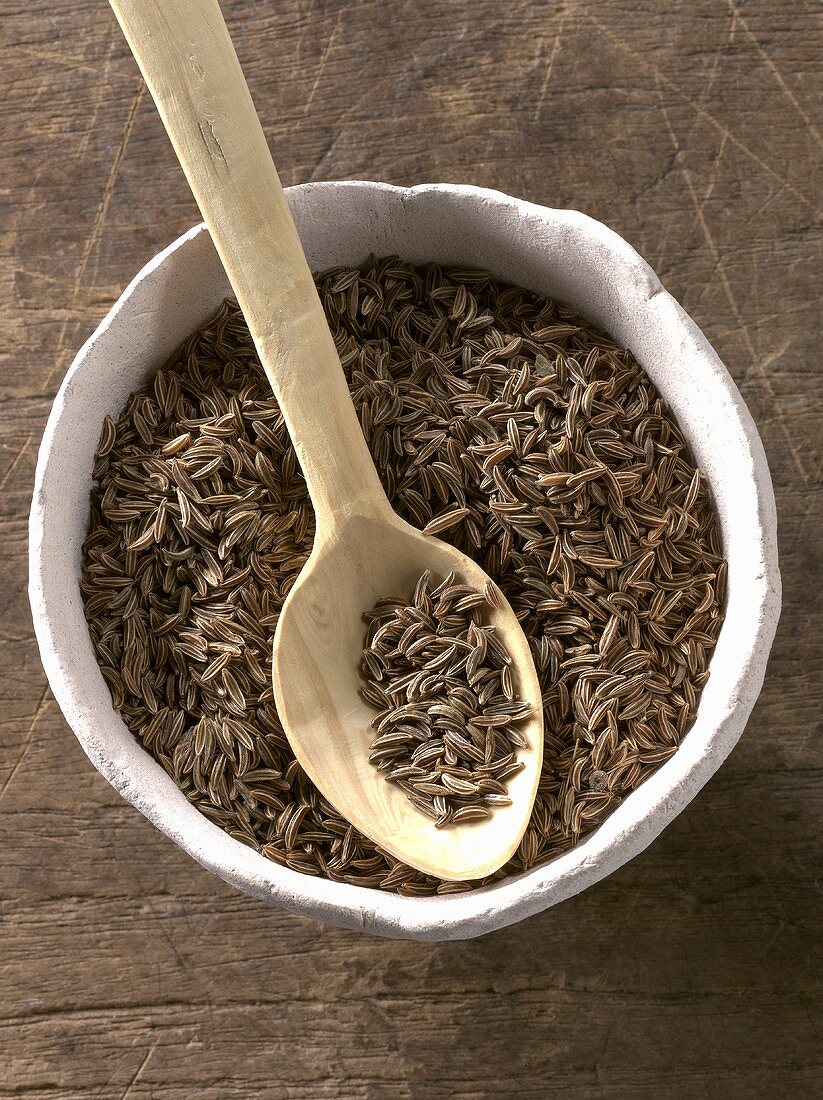 Caraway in bowl with wooden spoon
