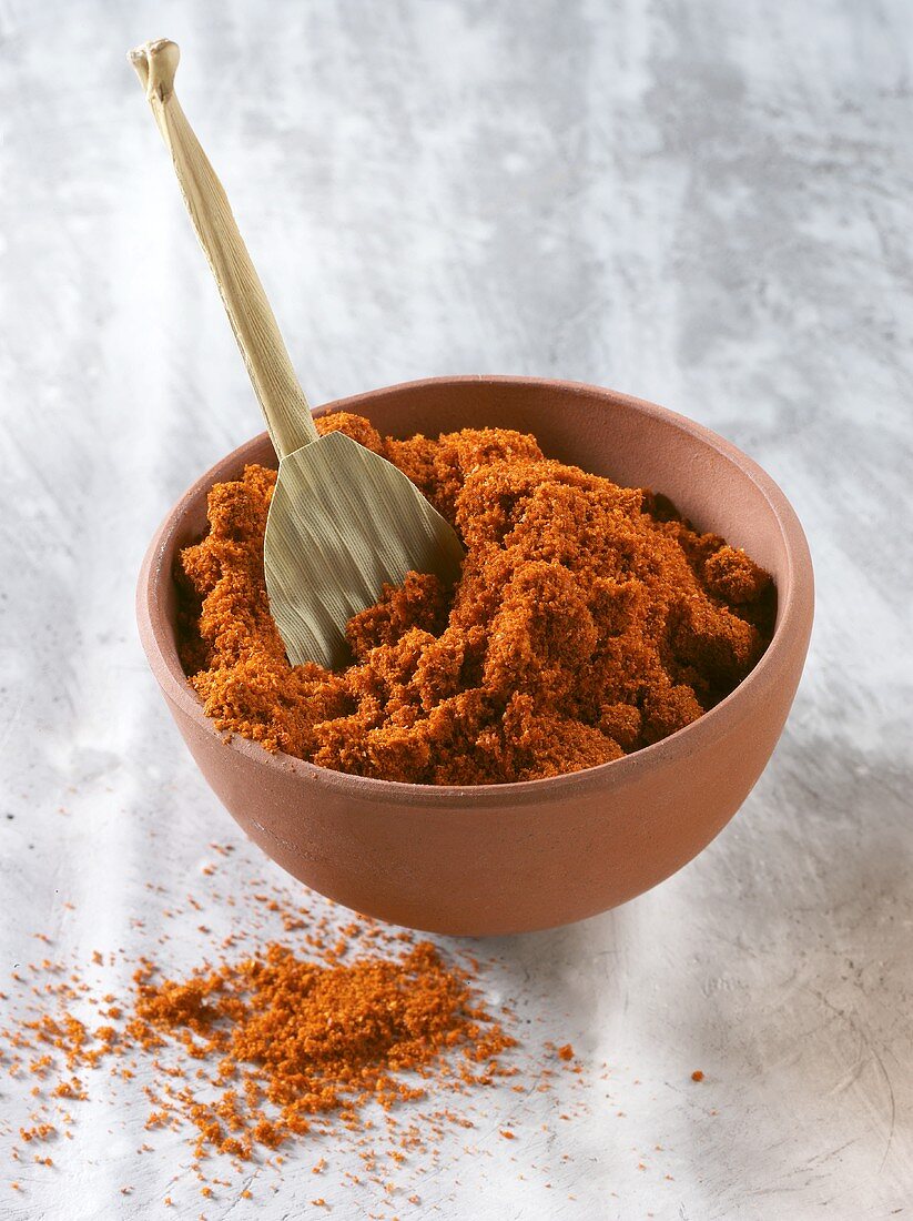 Cayenne pepper, ground, in bowl with spoon