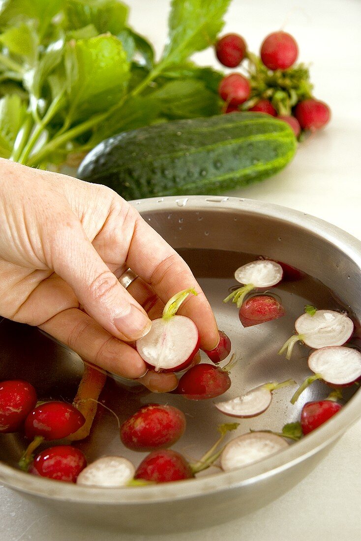 Washing radishes in a bowl