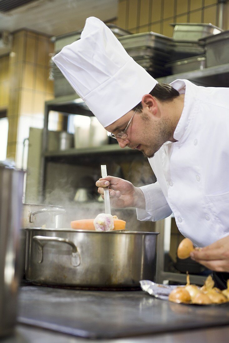 Chef checking a cooked carrot