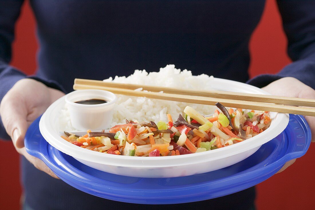 Asian vegetables with rice & soy sauce on plastic tableware