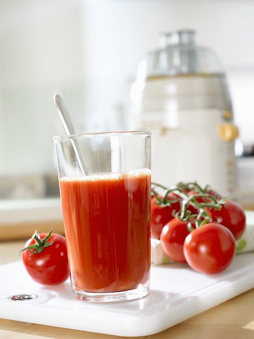 Tomatensaft, frische Tomaten und Saftpresse