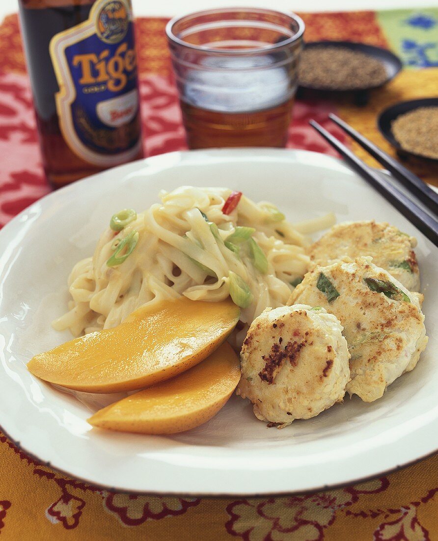 Fischfrikadellen mit Bandnudeln, Kokossauce und Mango (Asien)