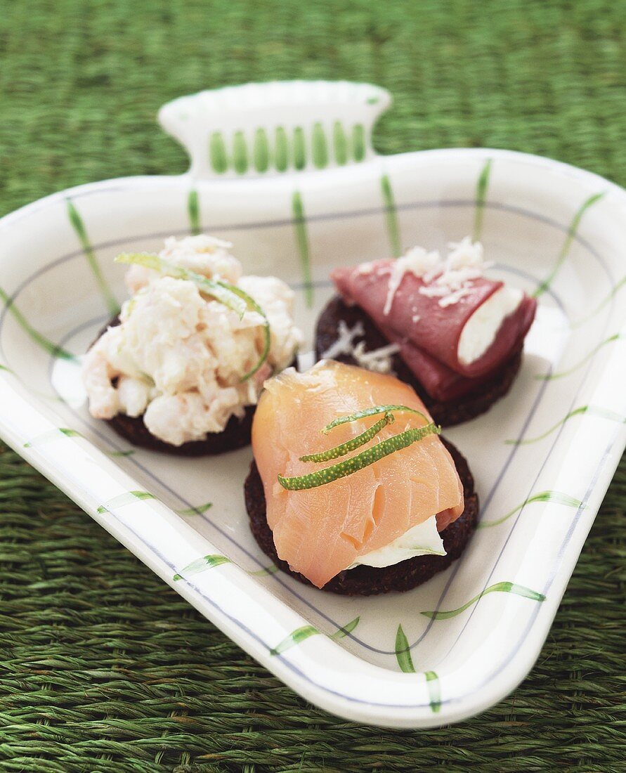 Three pumpernickel slices with smoked salmon, shrimp & reindeer