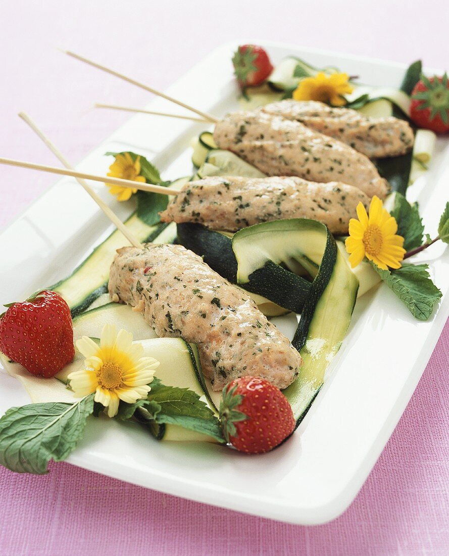 Salmon on sticks with courgettes, strawberries and flowers
