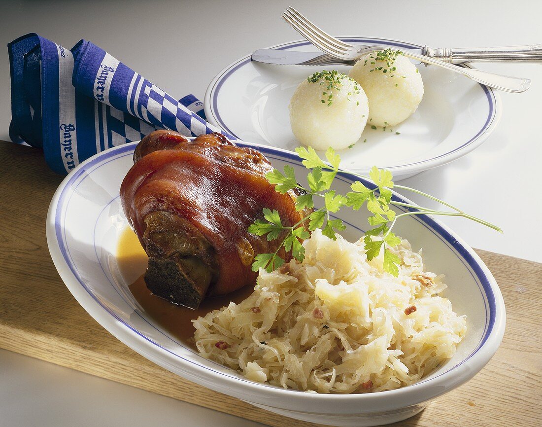 Gebratene Schweinshaxe mit Knödeln und Sauerkraut