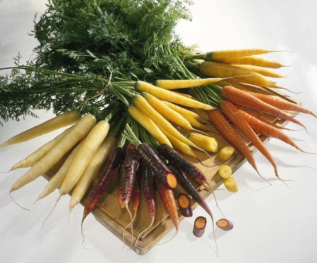 Various types of carrots on chopping board