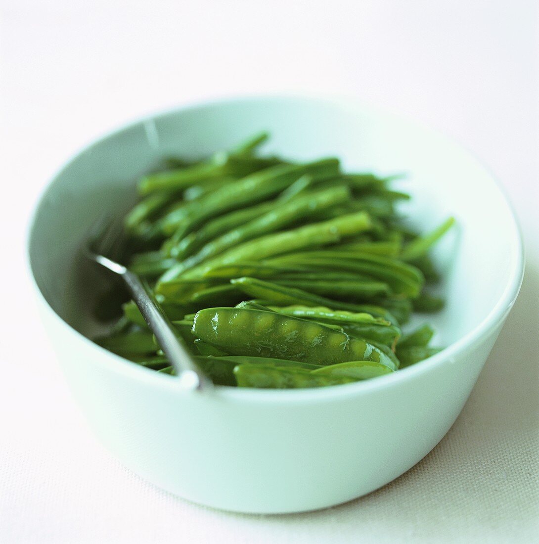 Mangetout and green beans in a white bowl