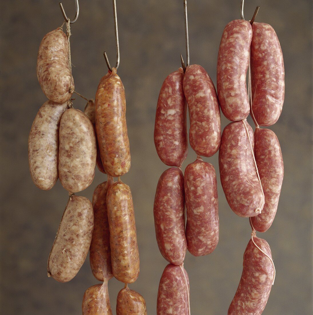 Various types of sausages, hanging on hooks