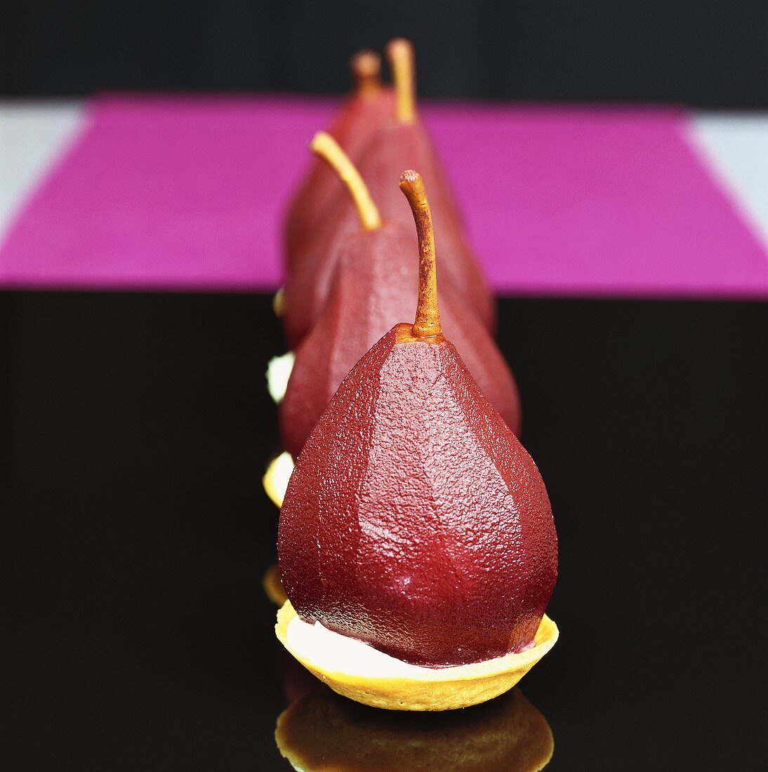 Pears poached in red wine on tart cases