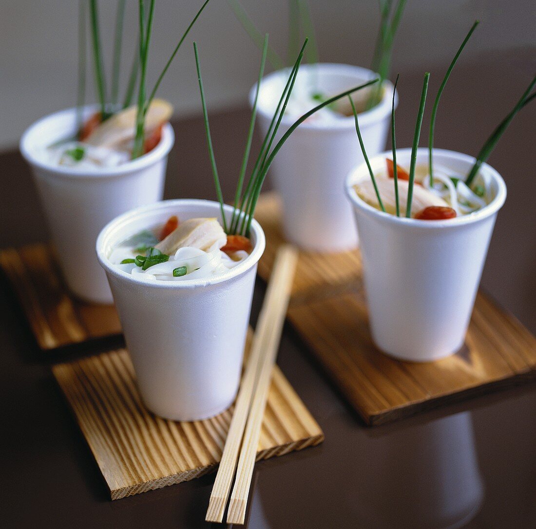 Rice noodles with chicken in plastic cups (Asia)