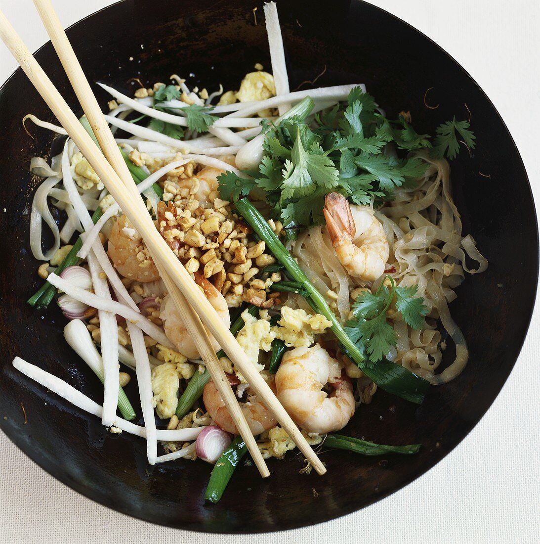 Rice noodles with shrimps and peanuts in a wok