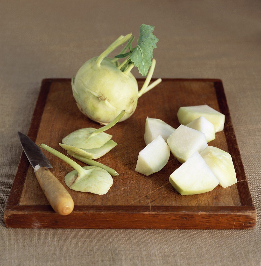Kohlrabi, whole and roughly diced, on chopping board