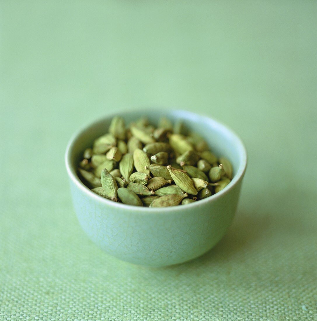 Cardamom pods in green bowl