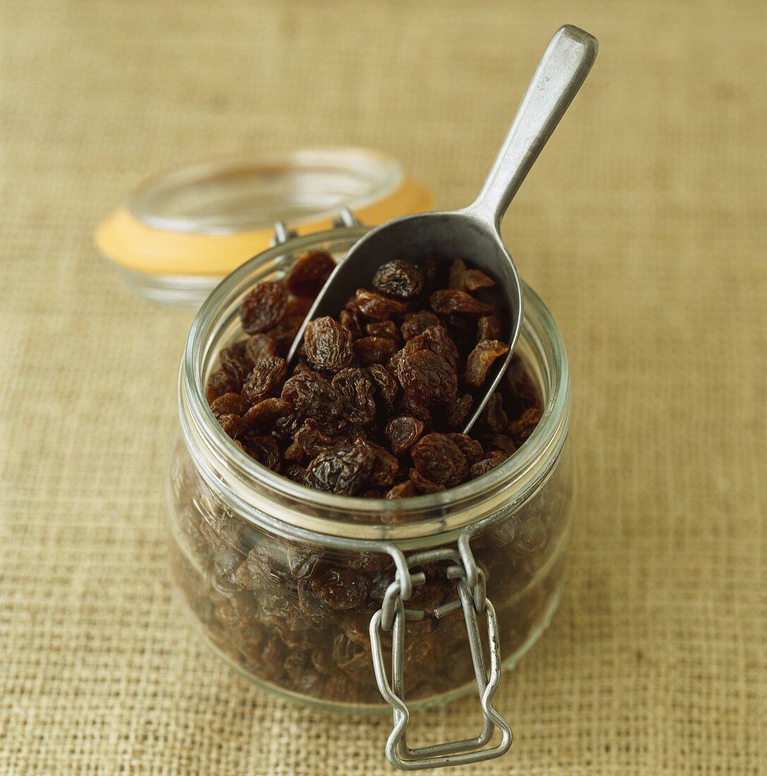 Raisins in a storage jar with a scoop