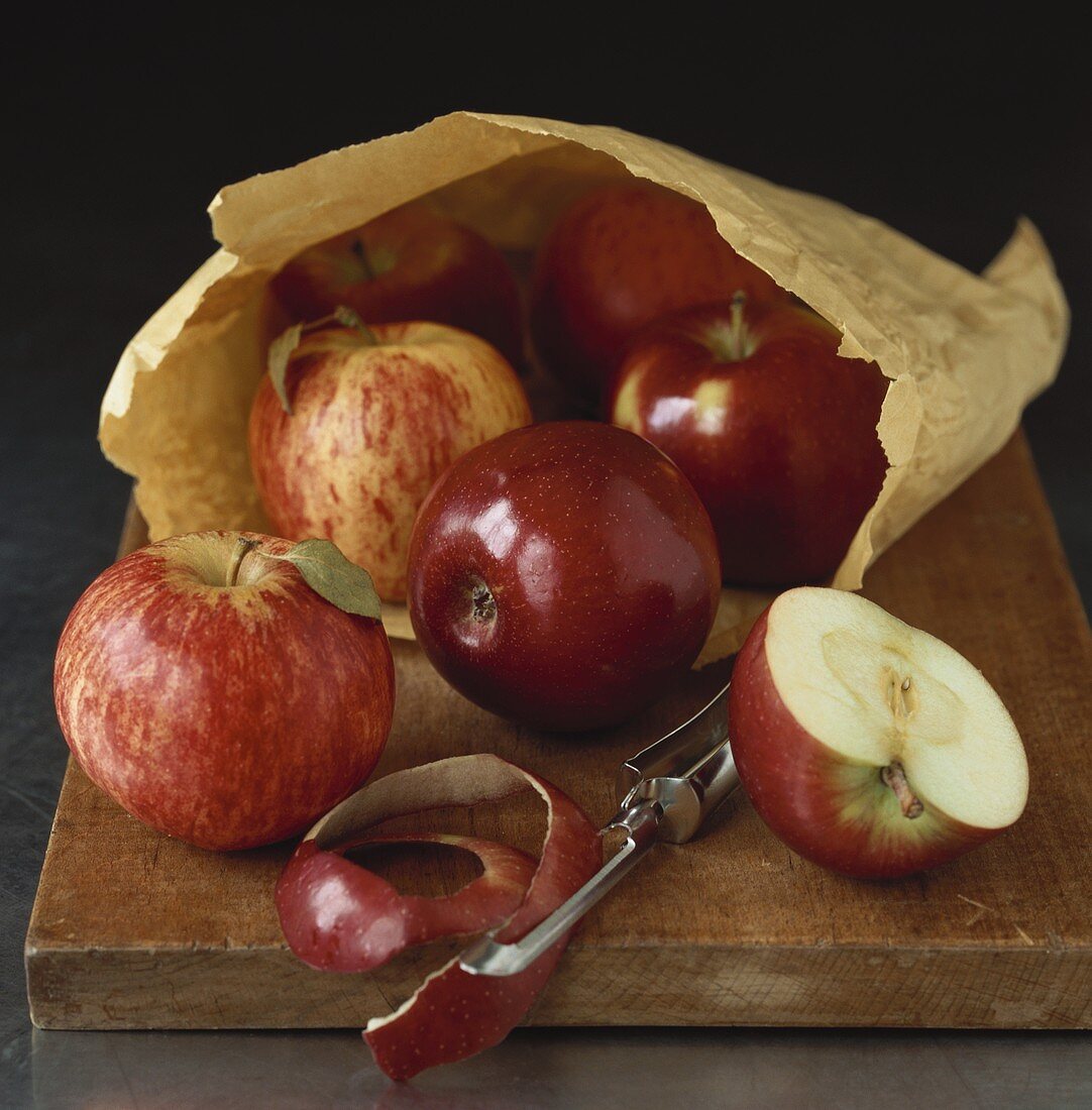 Red apples, whole, halved and apple peel, with paper bag
