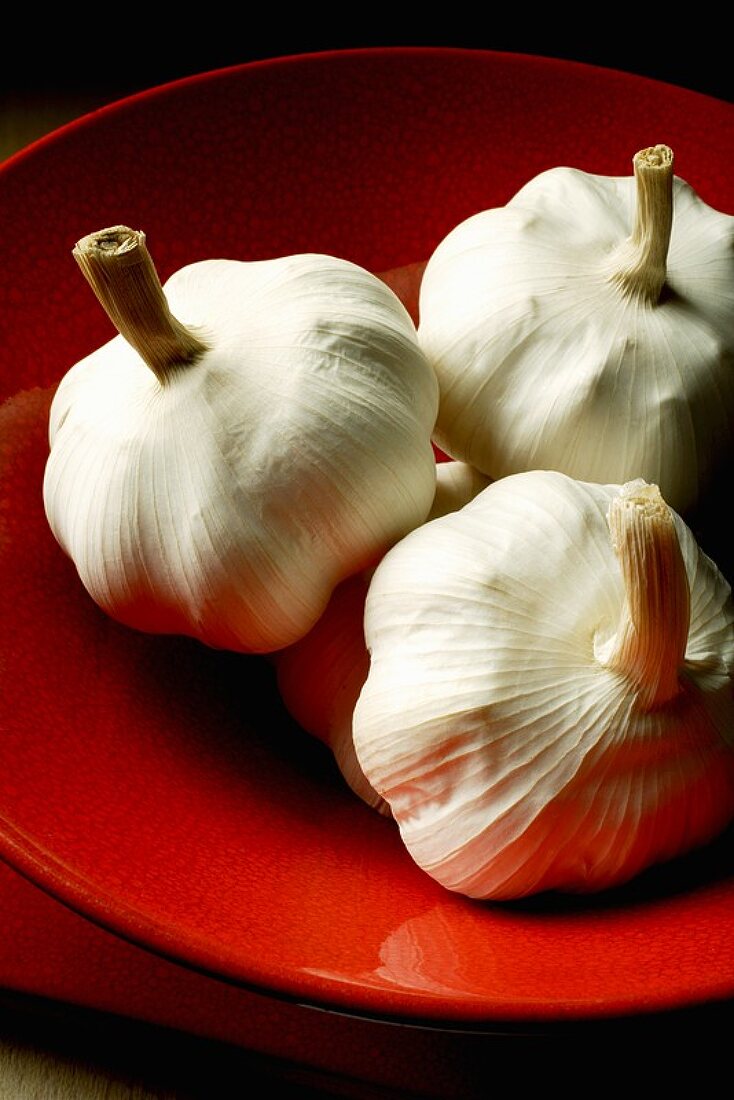 Garlic bulbs in a red bowl