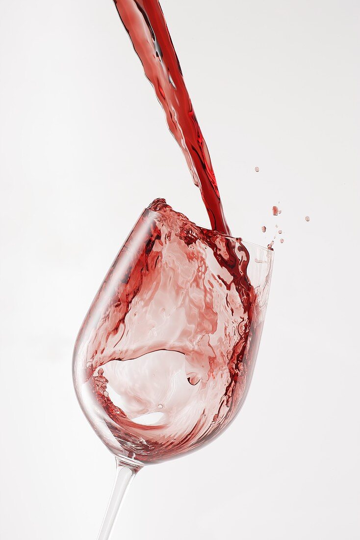 Rotwein in Glas gießen