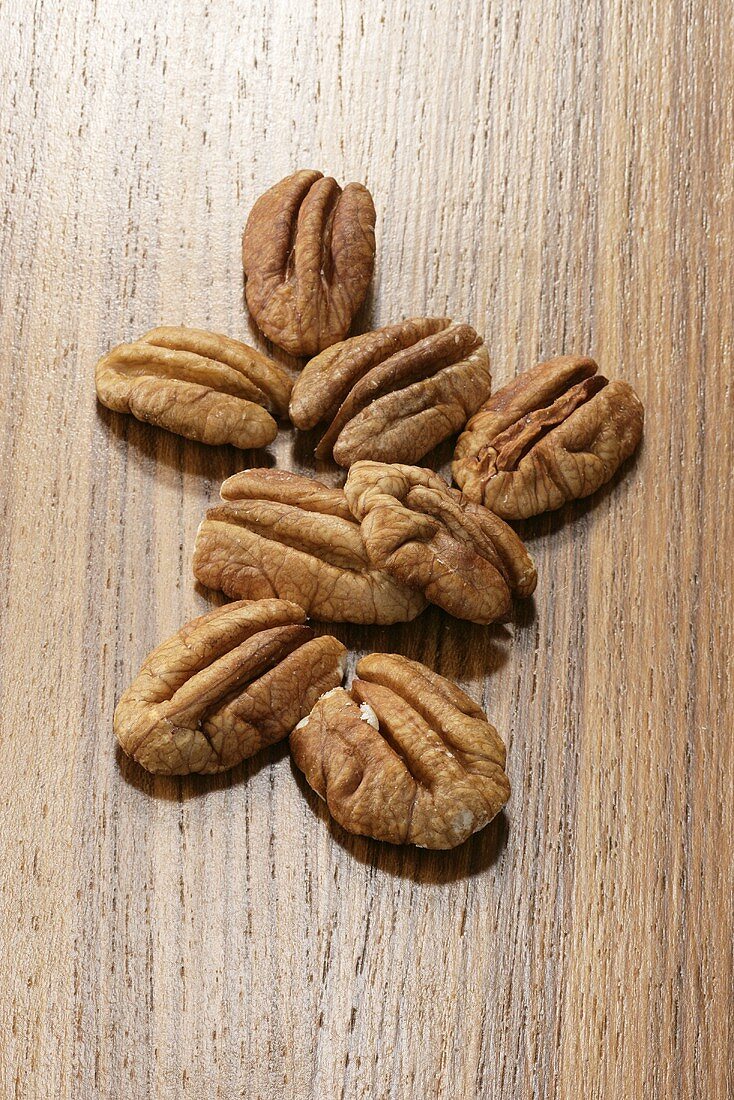 Several pecans on wooden background