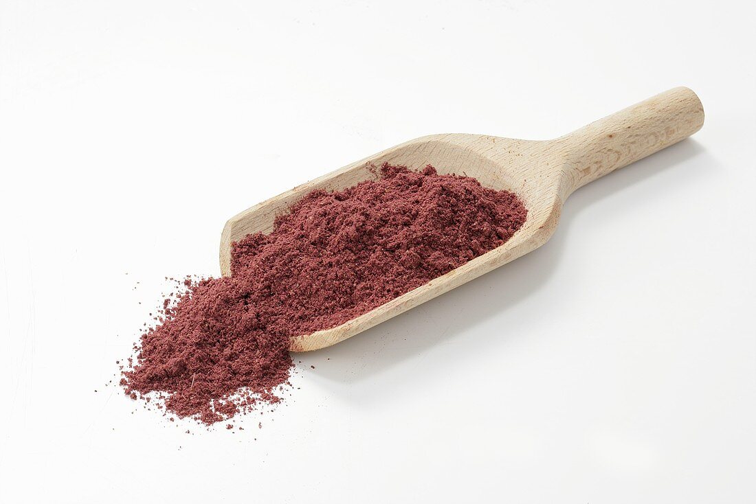Purple curry powder in wooden scoop