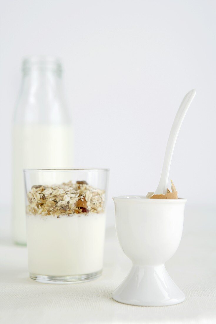 Muesli in a glass, shell of eaten boiled egg in eggcup