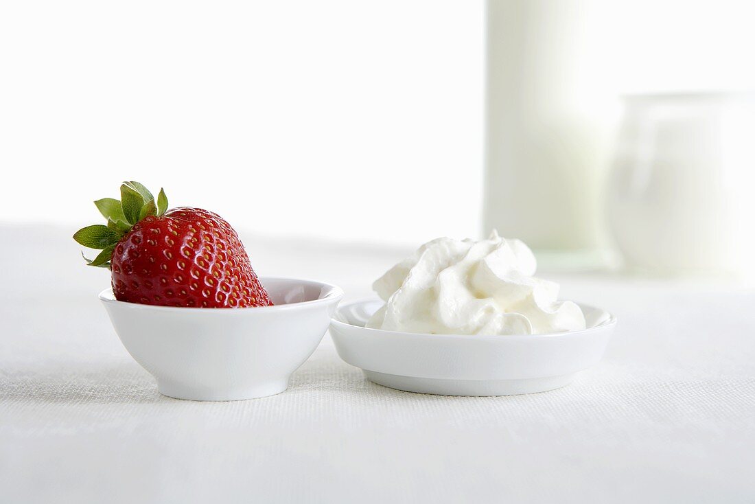 Fresh strawberry and cream in small dishes, yoghurt, milk