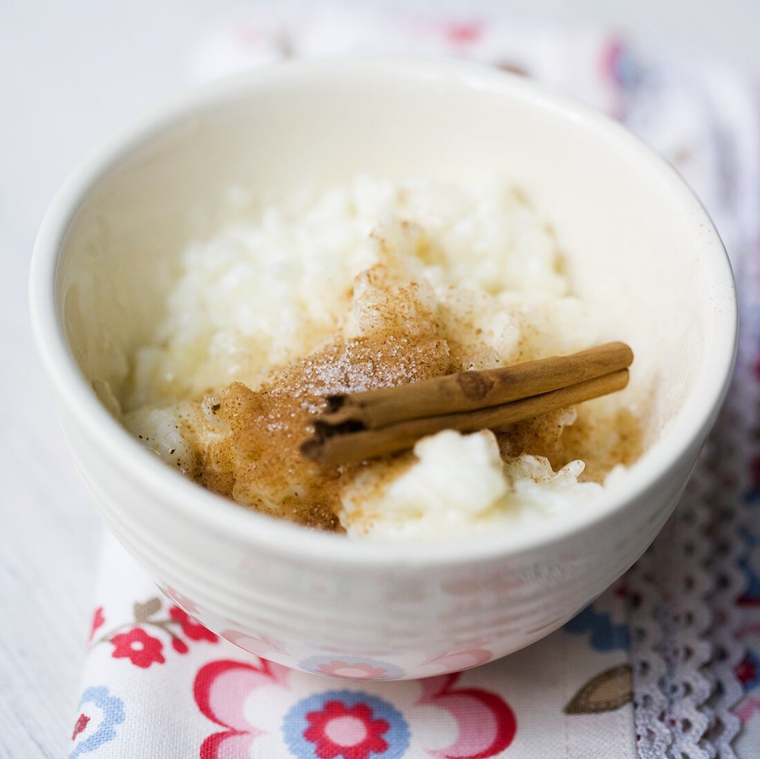 Rice pudding with cinnamon and sugar in a white bowl