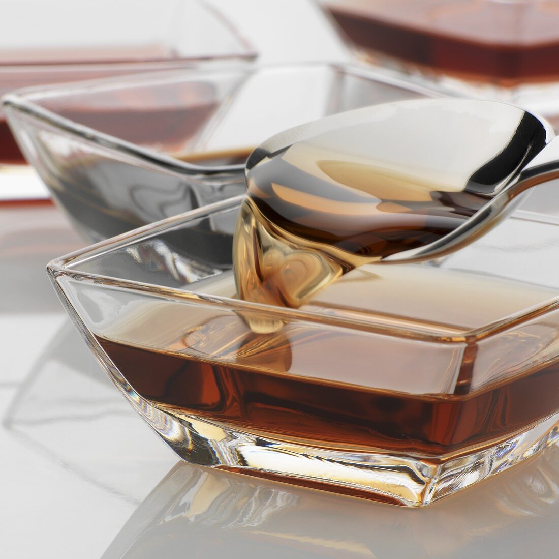 Various types of vinegar in glass dishes with spoon