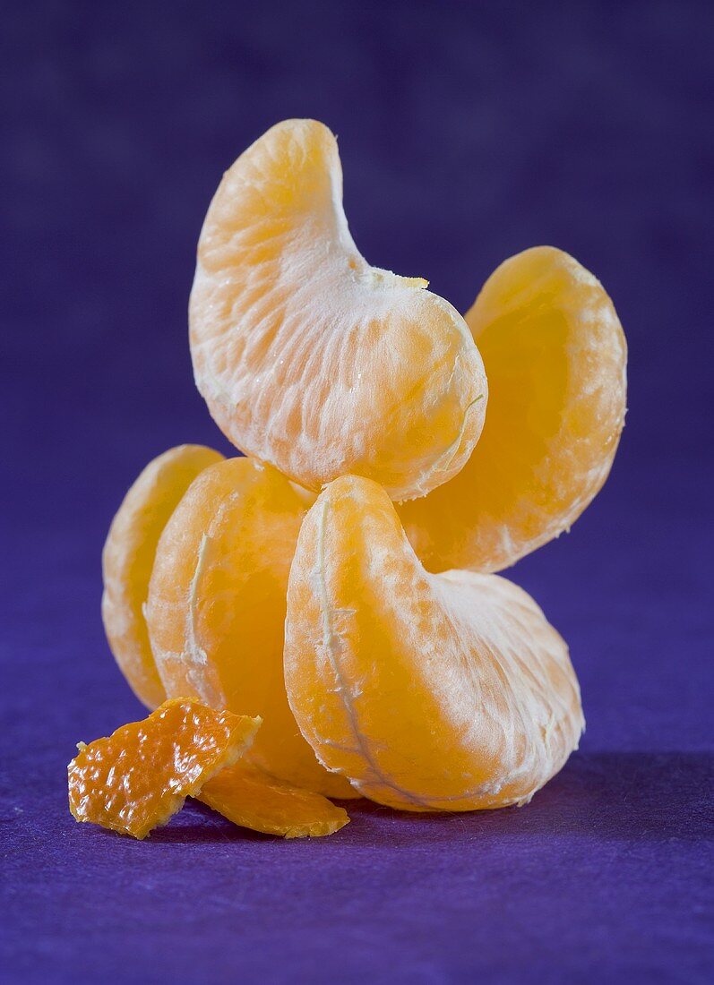 Mandarinensegmente und zwei Stückchen Mandarinenschale
