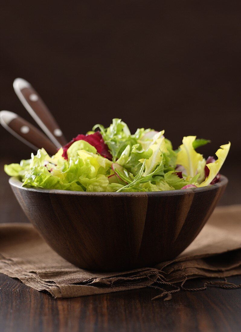 Mixed salad leaves in wooden bowl