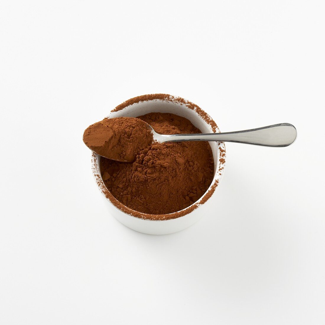 Cocoa powder in small dish with spoon